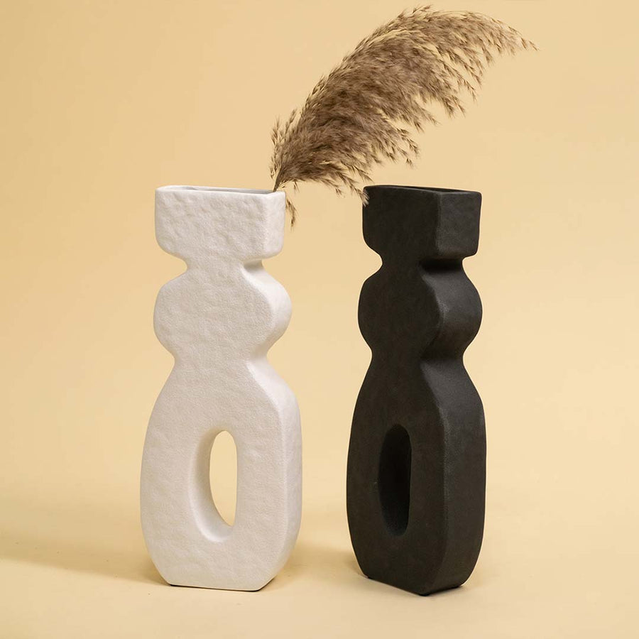 Set of black and white ceramic abstract sculptures with dried stems for artistic modern home decor displays.