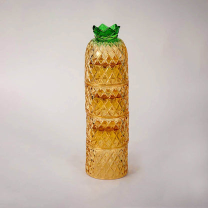 Decorative pineapple shaped amber glass tumbler set with textured diamond design and green lid for dining table styling.