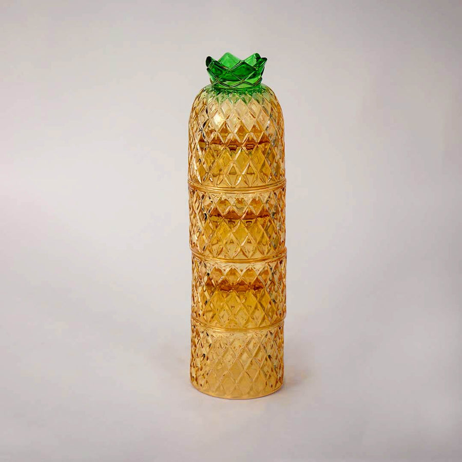Decorative pineapple shaped amber glass tumbler set with textured diamond design and green lid for dining table styling.