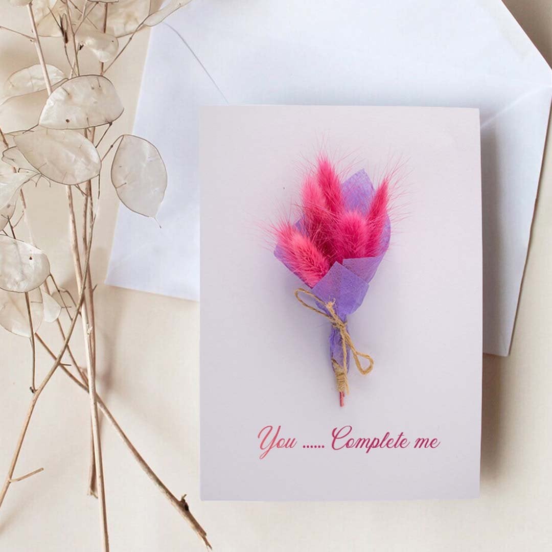 Love greeting card with pink and purple dried flower bouquet on white background perfect for romantic gift occasions.