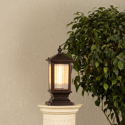 Black metal outdoor post lantern Light On on a stone gate pillar Traditional style Main Lifestyle image at night.