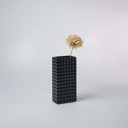 Black textured vase displayed on a minimal console table with dried flower decor for elegant home styling.
