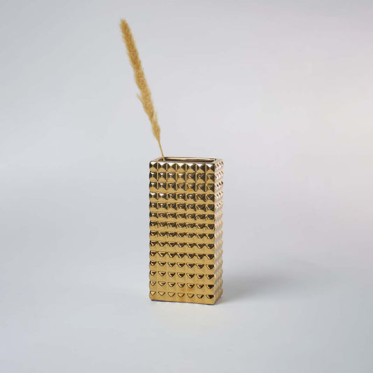 Modern gold textured vase placed in a minimal setting creating a bold metallic decor accent perfect for contemporary living spaces.