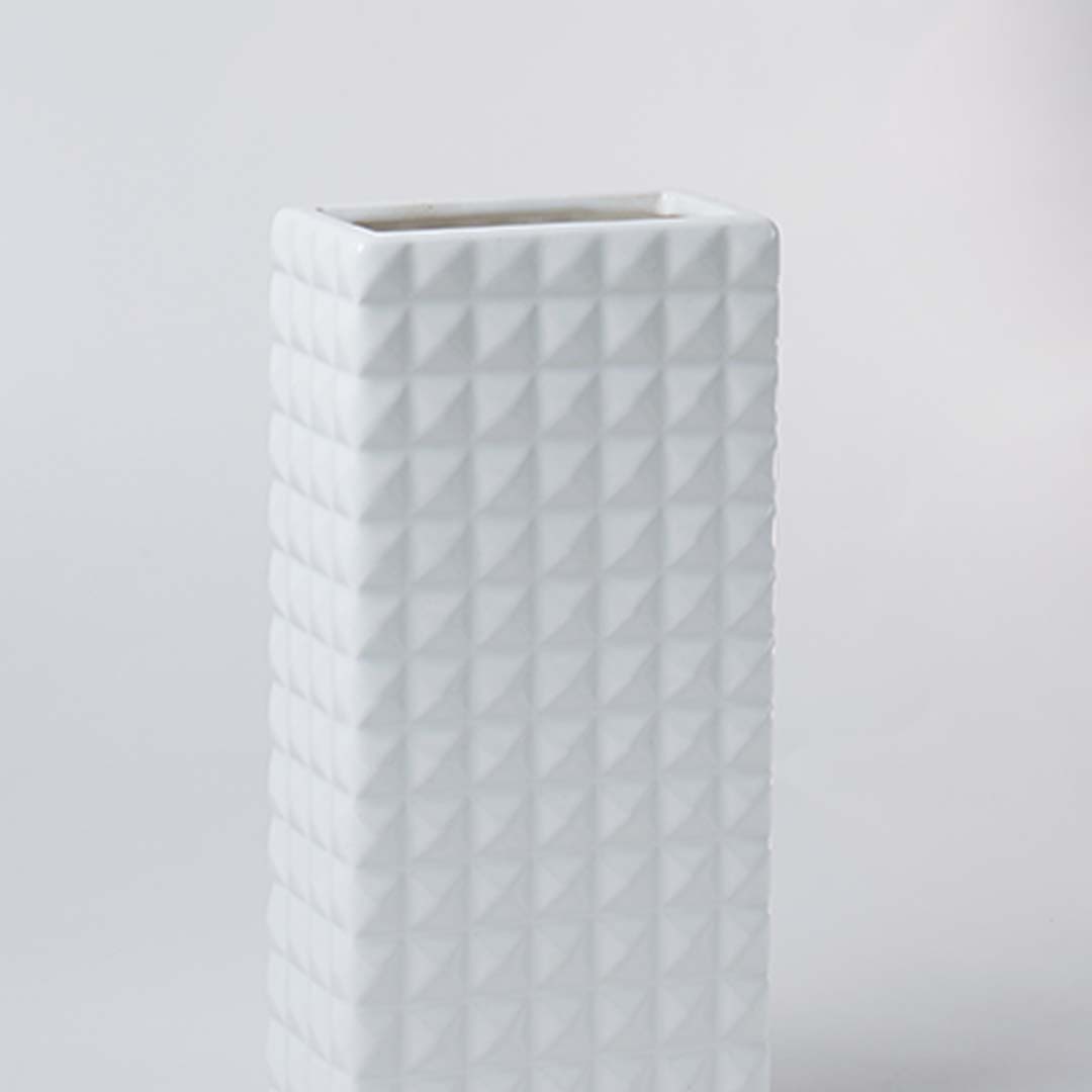Closeup of the white textured ceramic vase showing its raised geometric pattern and smooth finish for modern minimal home styling.