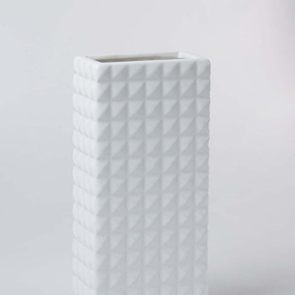 Closeup of the white textured ceramic vase showing its raised geometric pattern and smooth finish for modern minimal home styling.