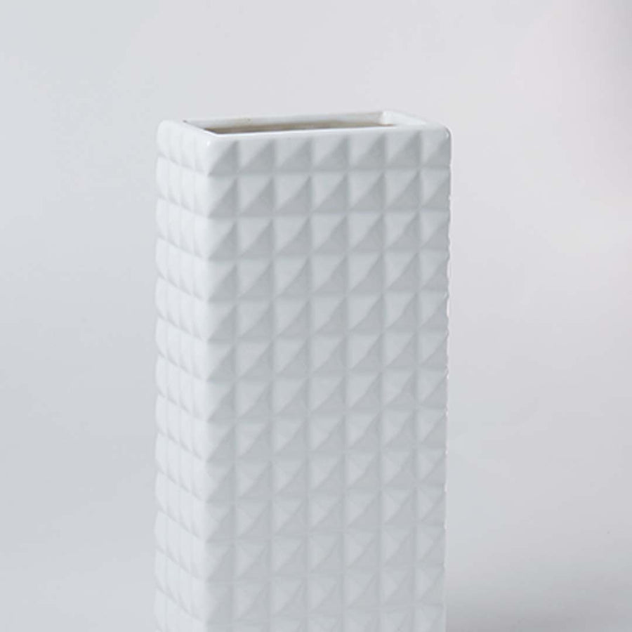 Closeup of the white textured ceramic vase showing its raised geometric pattern and smooth finish for modern minimal home styling.