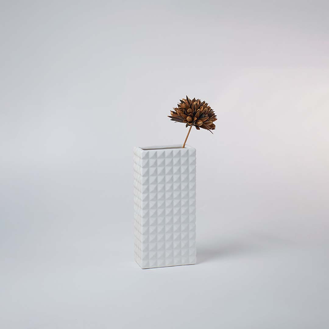 Minimal white geometric ceramic vase placed on a soft background creating a clean modern look ideal for subtle contemporary home decor.