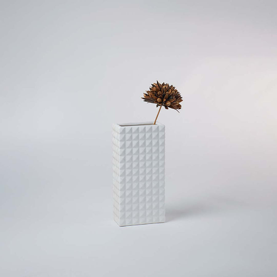 Minimal white geometric ceramic vase placed on a soft background creating a clean modern look ideal for subtle contemporary home decor.
