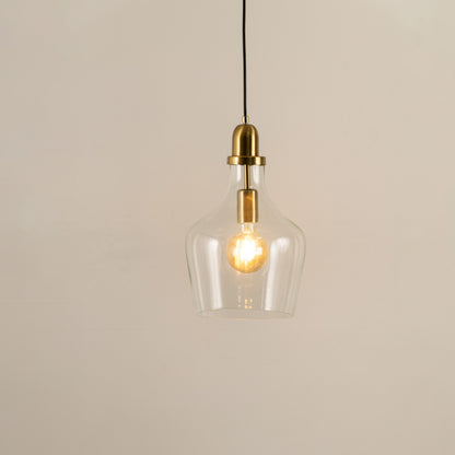 Clear glass and brass metal pendant light with warm glow for elegant contemporary home decor spaces.