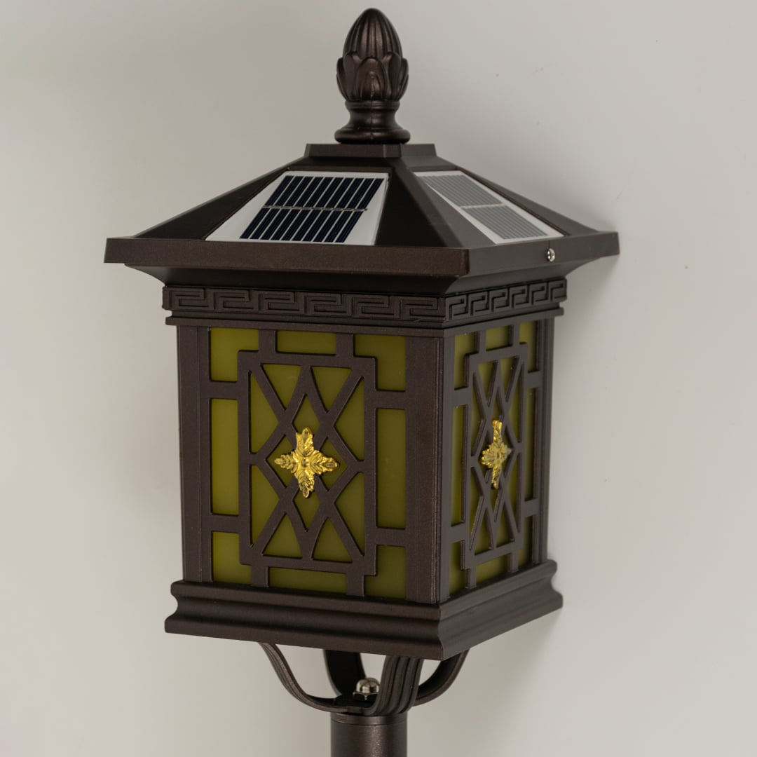 Closeup of brown solar garden lantern showing patterned glass panels and classic carved detailing ideal for warm decorative outdoor lighting.