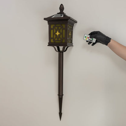 Brown solar garden spike lantern with patterned glass shown with light off on a white background showcasing its elegant frame and tall spike structure.