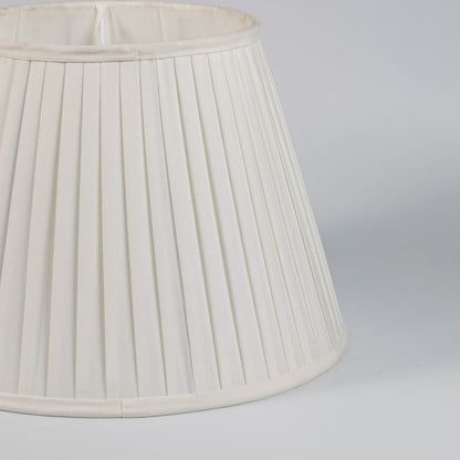 Closeup view of cream pleated fabric lampshade showcasing fine folds and handcrafted texture for refined interiors.