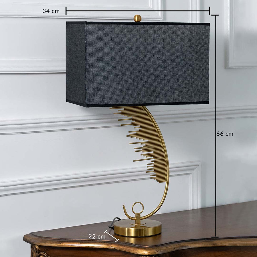 Gold artistic curved table lamp with black rectangular shade shown with dimensions of 34 cm width 66 cm height and 22 cm depth ideal for side tables or consoles.