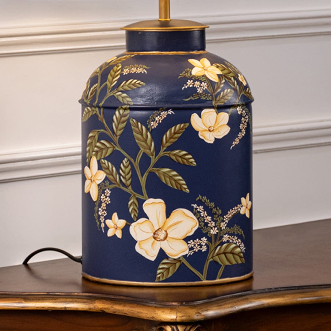 Table lamp closeup displaying dark ceramic base with golden floral artwork and refined decorative craftsmanship.