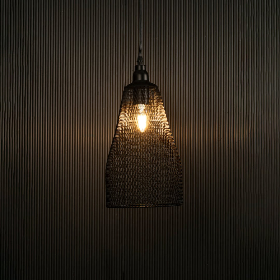 Elegant black mesh pendant hanging light illuminated against dark background highlighting its refined craftsmanship and industrial texture.