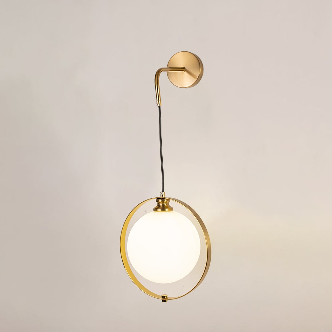 Gold ring wall light with frosted glass globe glowing softly on a clean white background showcasing elegant modern lighting.