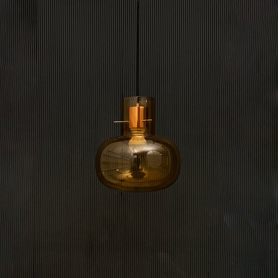 Elegant amber glass hanging pendant light displayed on dark background with light turned off for stylish look.