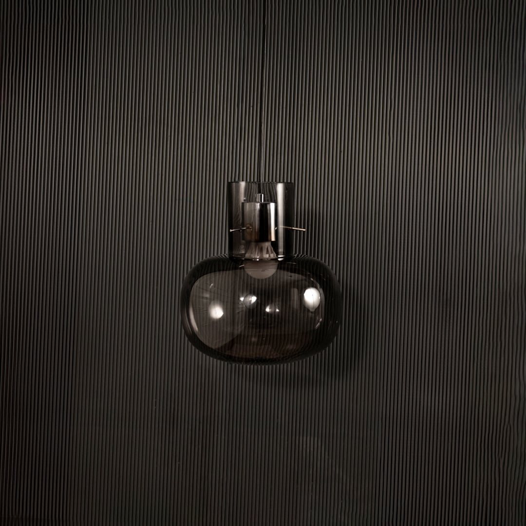 Contemporary grey glass hanging pendant light displayed on dark background with light turned off for elegant appeal.