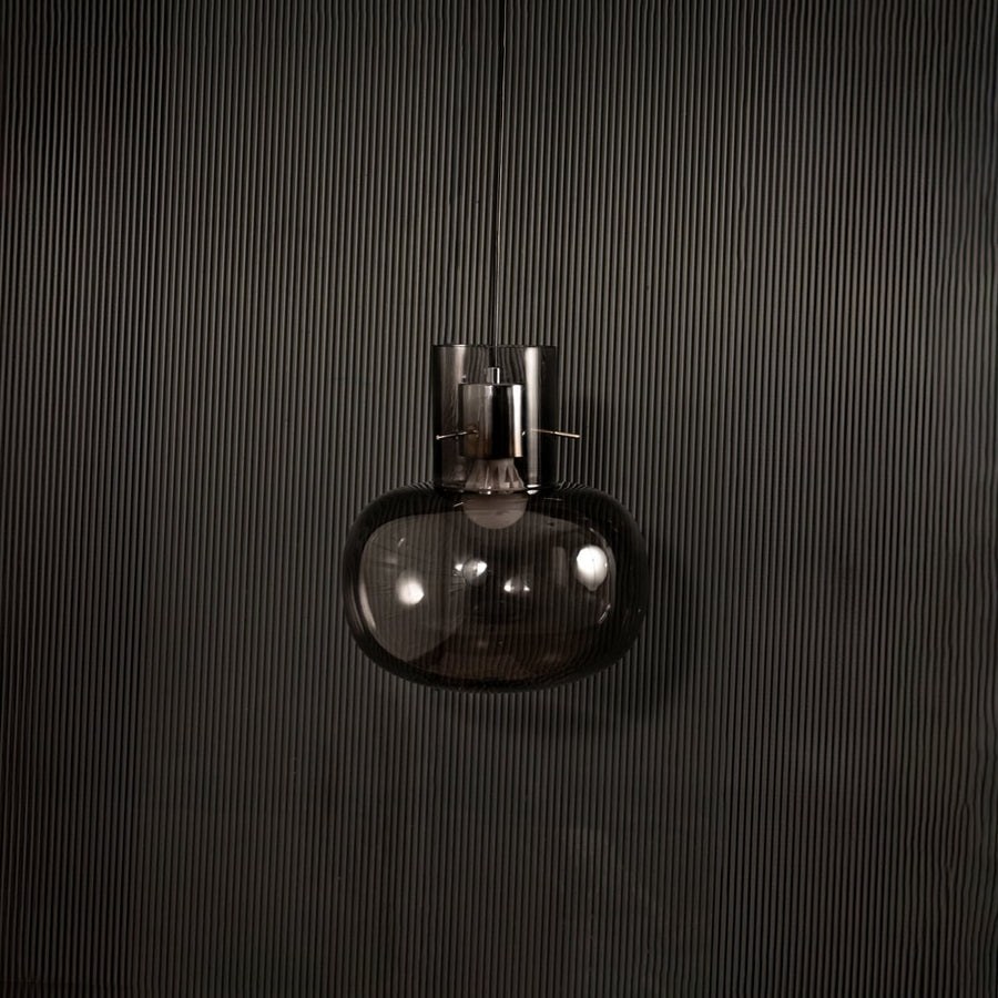 Contemporary grey glass hanging pendant light displayed on dark background with light turned off for elegant appeal.