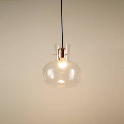 Transparent glass hanging pendant light glowing softly on white background for elegant and modern room ambience.