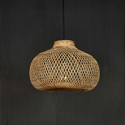 Rattan pendant light displayed off on black background showing intricate handmade weave and organic shape.