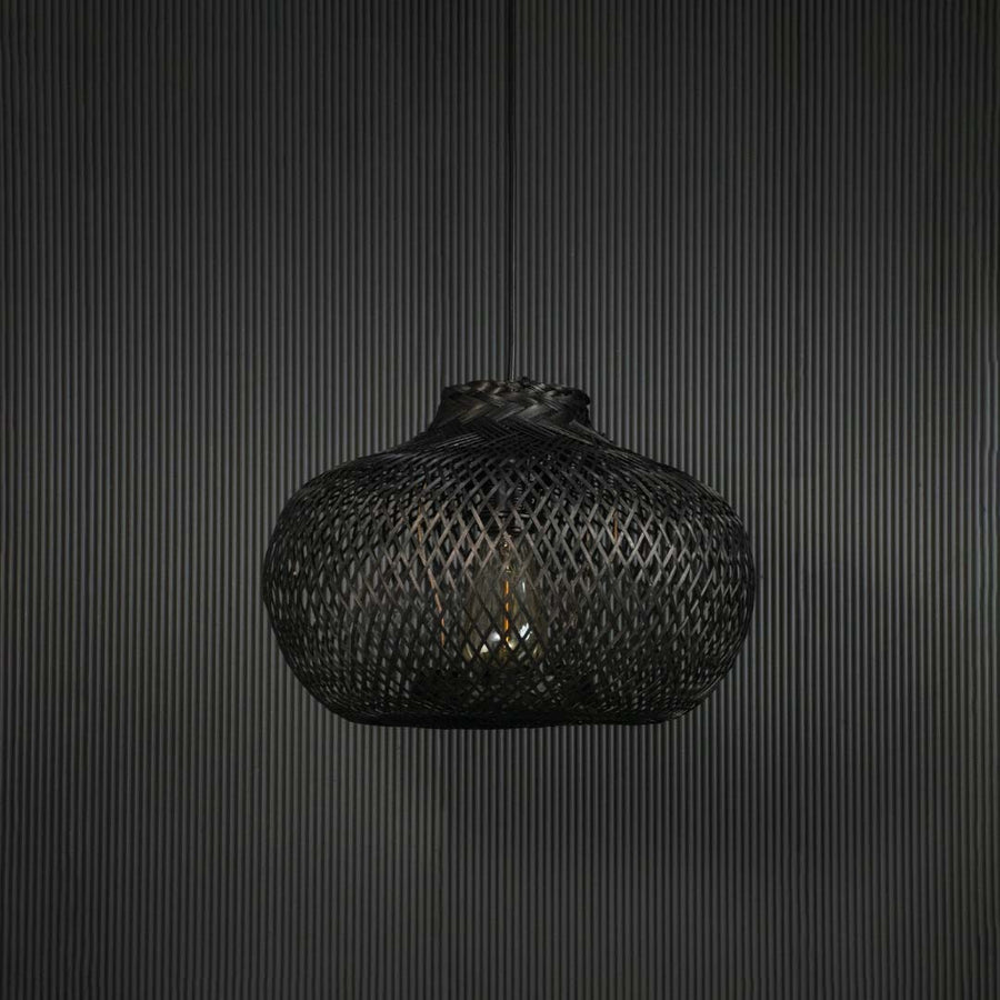 Black rattan pendant light hanging fixture with artisanal weave adding modern ambience to dining spaces.