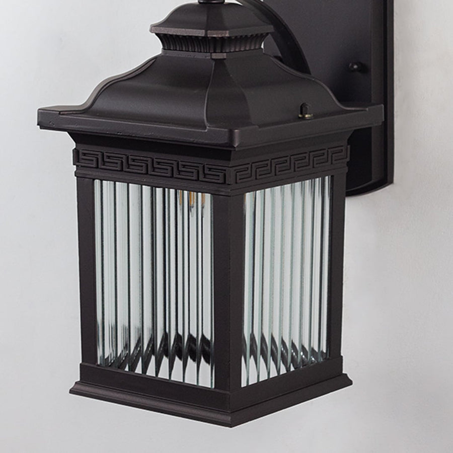 Closeup of outdoor wall lantern with black metal frame and ribbed clear glass panels highlighting classic design and durable exterior build.