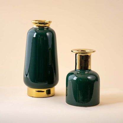 A tall and short green ceramic vase set with gold necks is displayed together showing their glossy surfaces and stylish modern shapes on a neutral background.