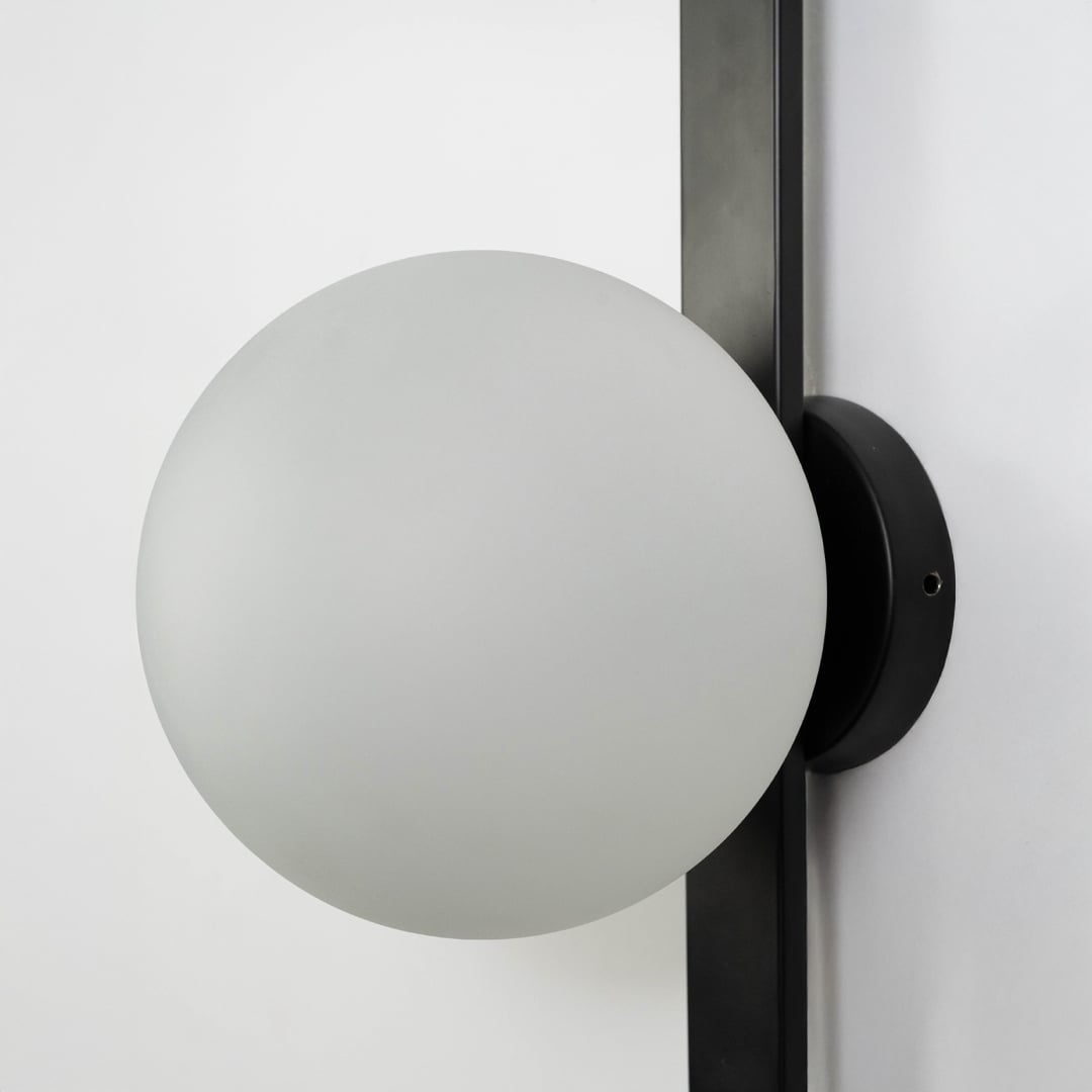 Closeup of oval frosted glass lamp shade on black metal fixture showcasing smooth matte finish and quality build.