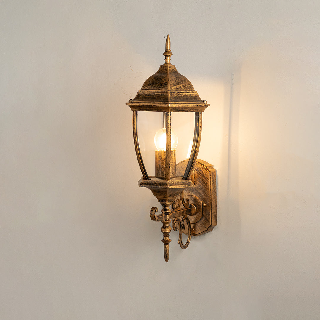 Vintage bronze outdoor wall light on white background with clear glass shade for classic exterior decor.