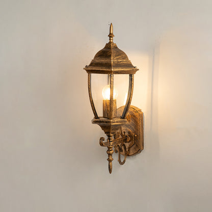 Vintage bronze outdoor wall light on white background with clear glass shade for classic exterior decor.