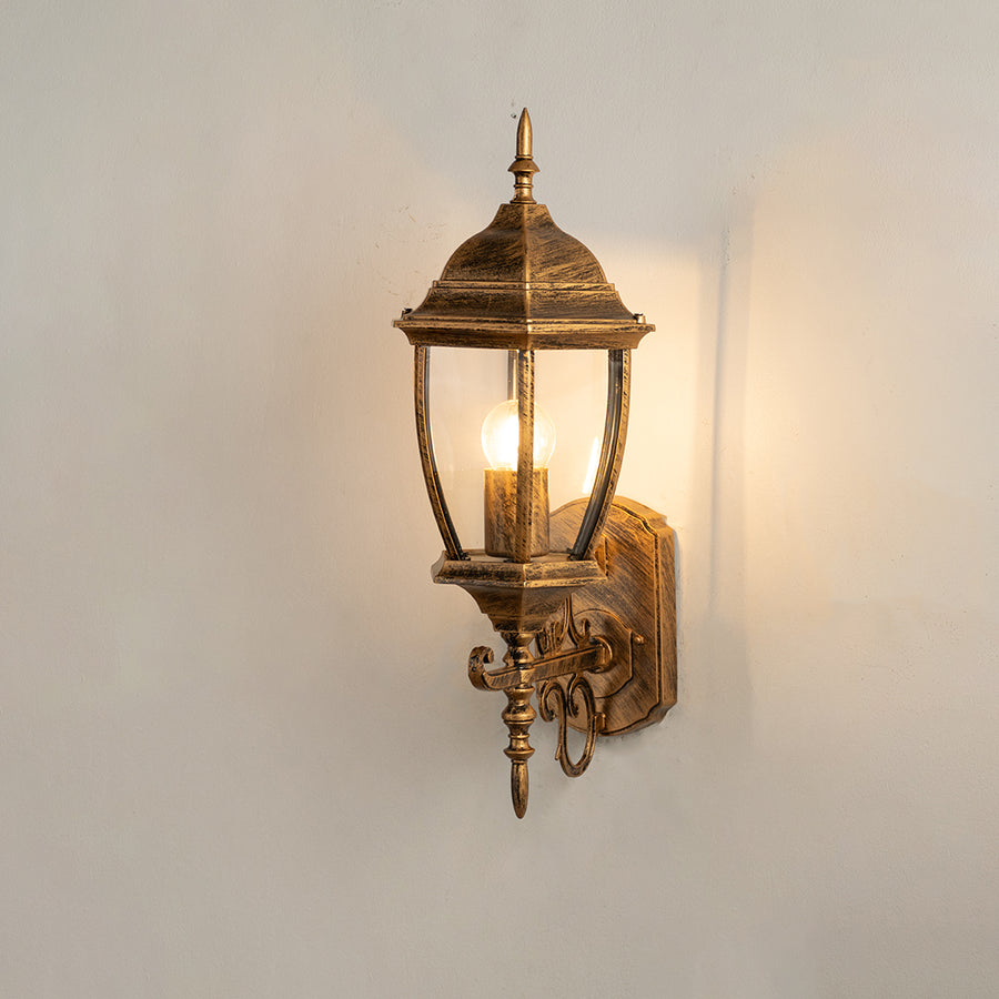Vintage bronze outdoor wall light on white background with clear glass shade for classic exterior decor.