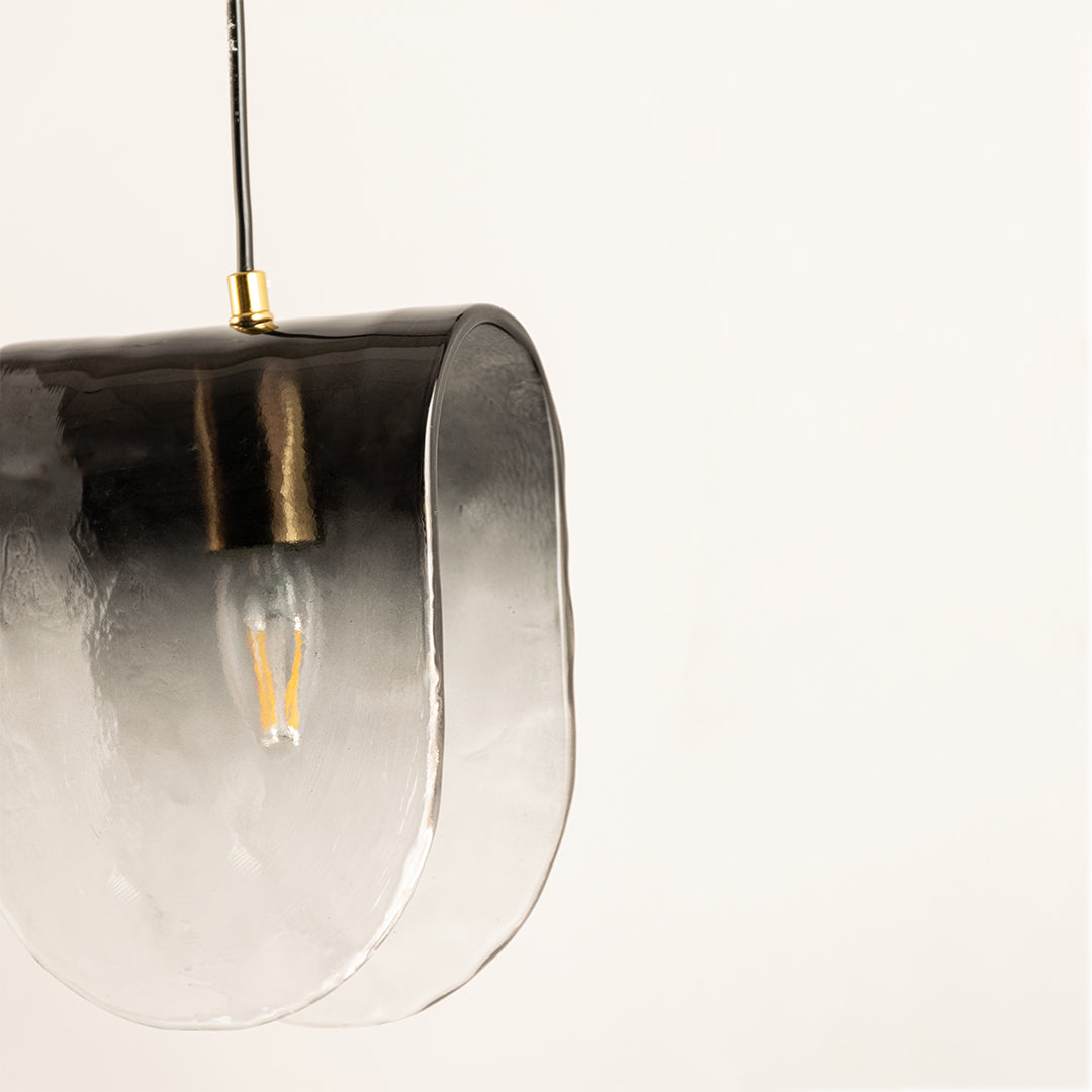 Closeup of smoked glass and black metal hanging wall light for elegant modern decor styling spaces.