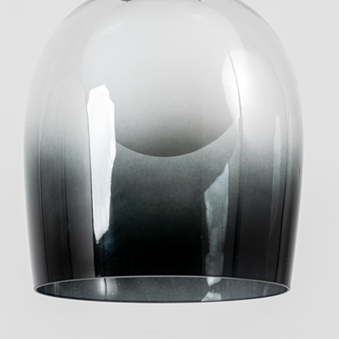 Closeup of smokey glass dome pendant light with modern black metal fitting designed for elegant home interiors.