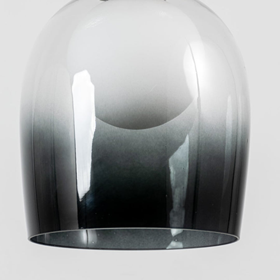 Closeup of smokey glass dome pendant light with modern black metal fitting designed for elegant home interiors.