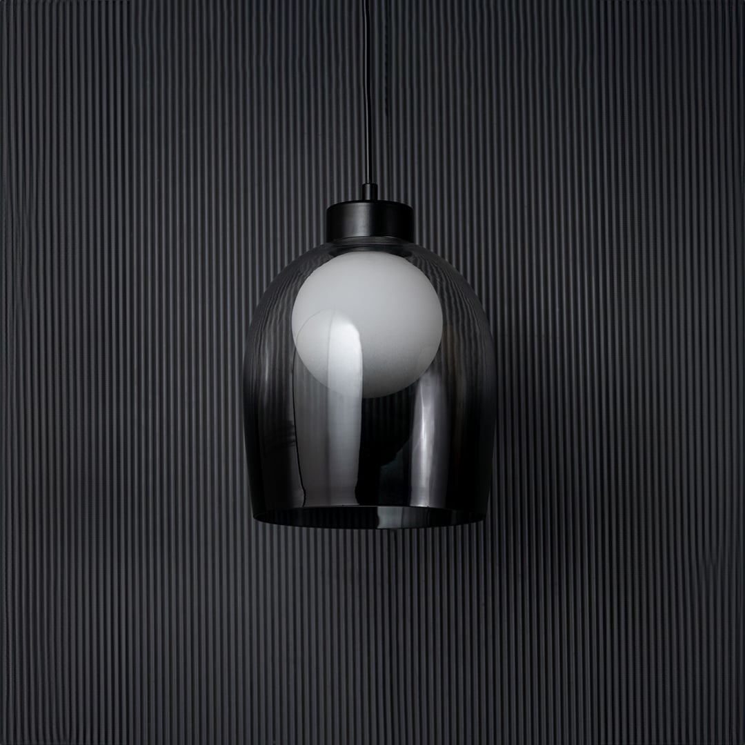 Smokey glass dome pendant light bulb off on black background with elegant cylindrical shade and modern fitting.