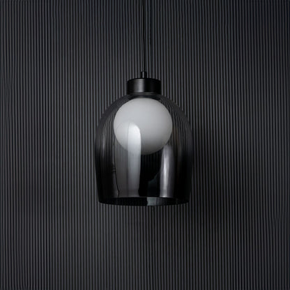 Smokey glass dome pendant light bulb off on black background with elegant cylindrical shade and modern fitting.