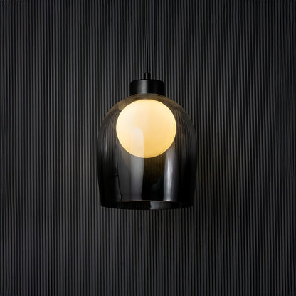 Smokey glass pendant light glowing on black background with elegant dome design and modern style fitting decor.