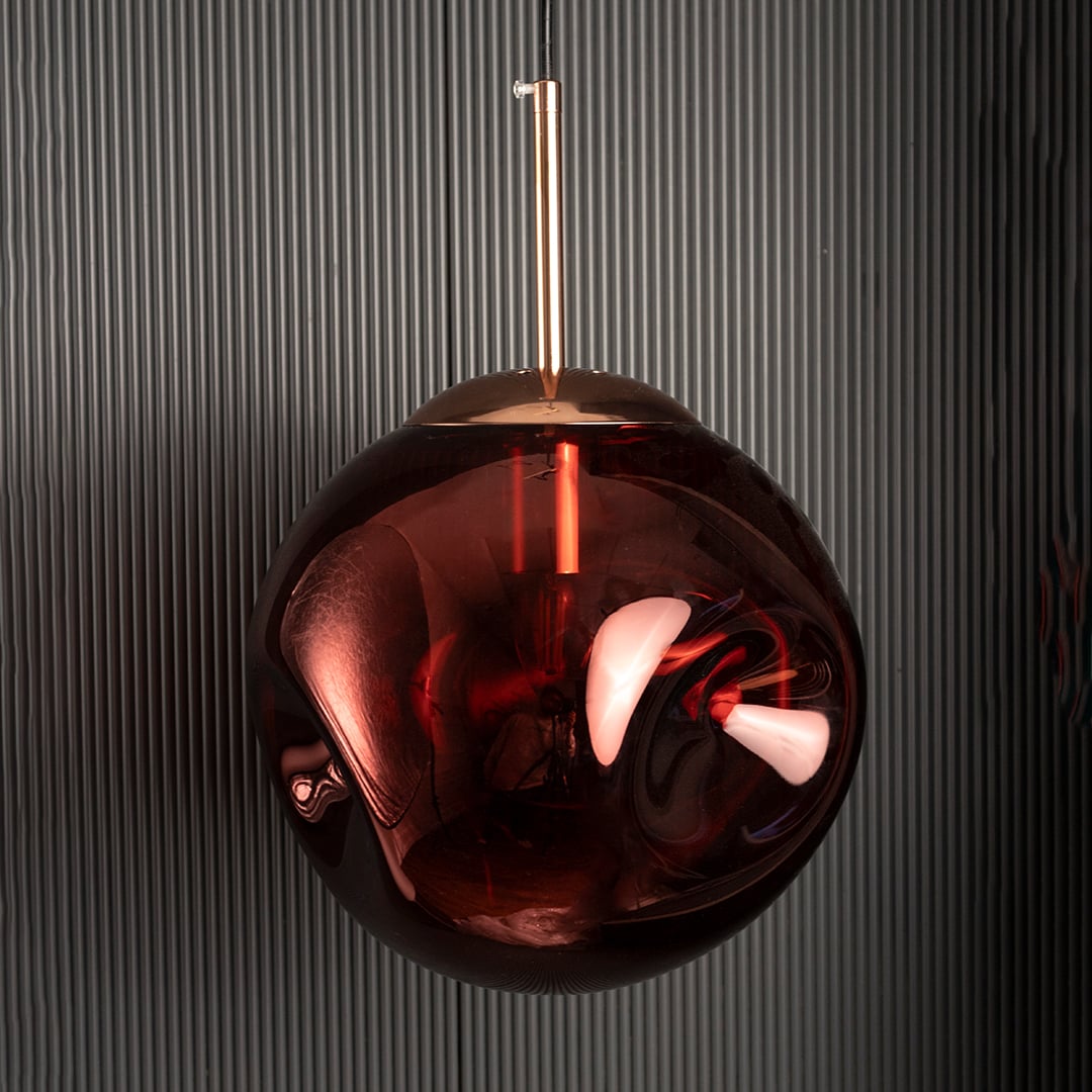 Red glass pendant light with gold top shown on black background ideal for adding depth and luxury to interiors.