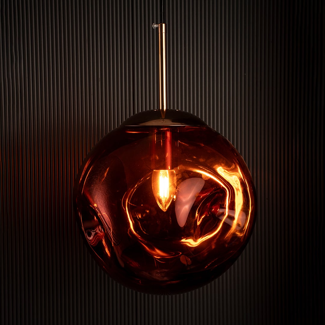 Red glass globe pendant lamp glowing brightly on black background adding warmth and sophistication to interiors.