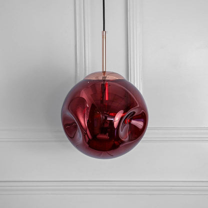 Modern red glass pendant light with metallic holder shown on white background perfect for elegant home decor.
