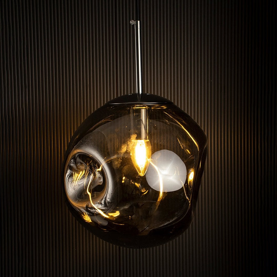 Elegant smoky glass pendant lamp glowing warmly on black background creating depth and sophistication in interiors.