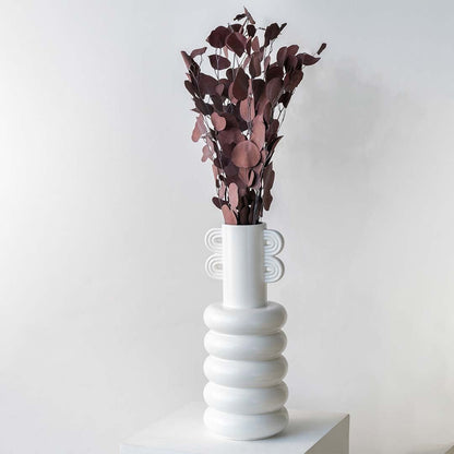 Deep red dried eucalyptus stems styled in a warm modern room adding rich earthy texture to contemporary home decor.