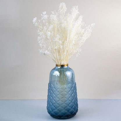 White dried gypsophila bouquet preserved flowers styled in blue glass vase lifestyle decor on table background.