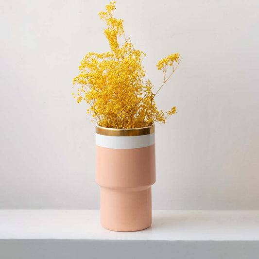 Vibrant yellow dried gypsophila flowers arranged in minimalist ceramic vase adding color to modern interior space.