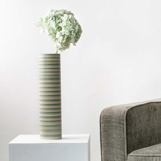 Soft mint green dried hydrangea stem styled in a modern room adding a fresh natural accent to contemporary home decor.