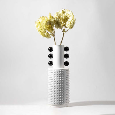 Modern ceramic vase in white with black ball design styled with artificial green hydrangea flower for elegant home decor.