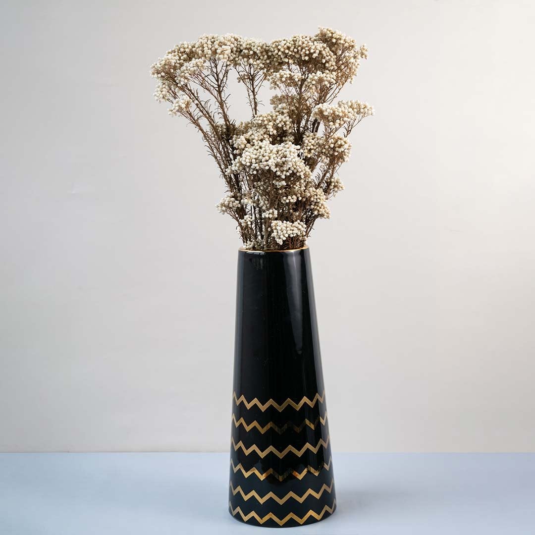 Brown dried gypsophila bouquet preserved flowers styled in tall black ceramic vase lifestyle home decor display.