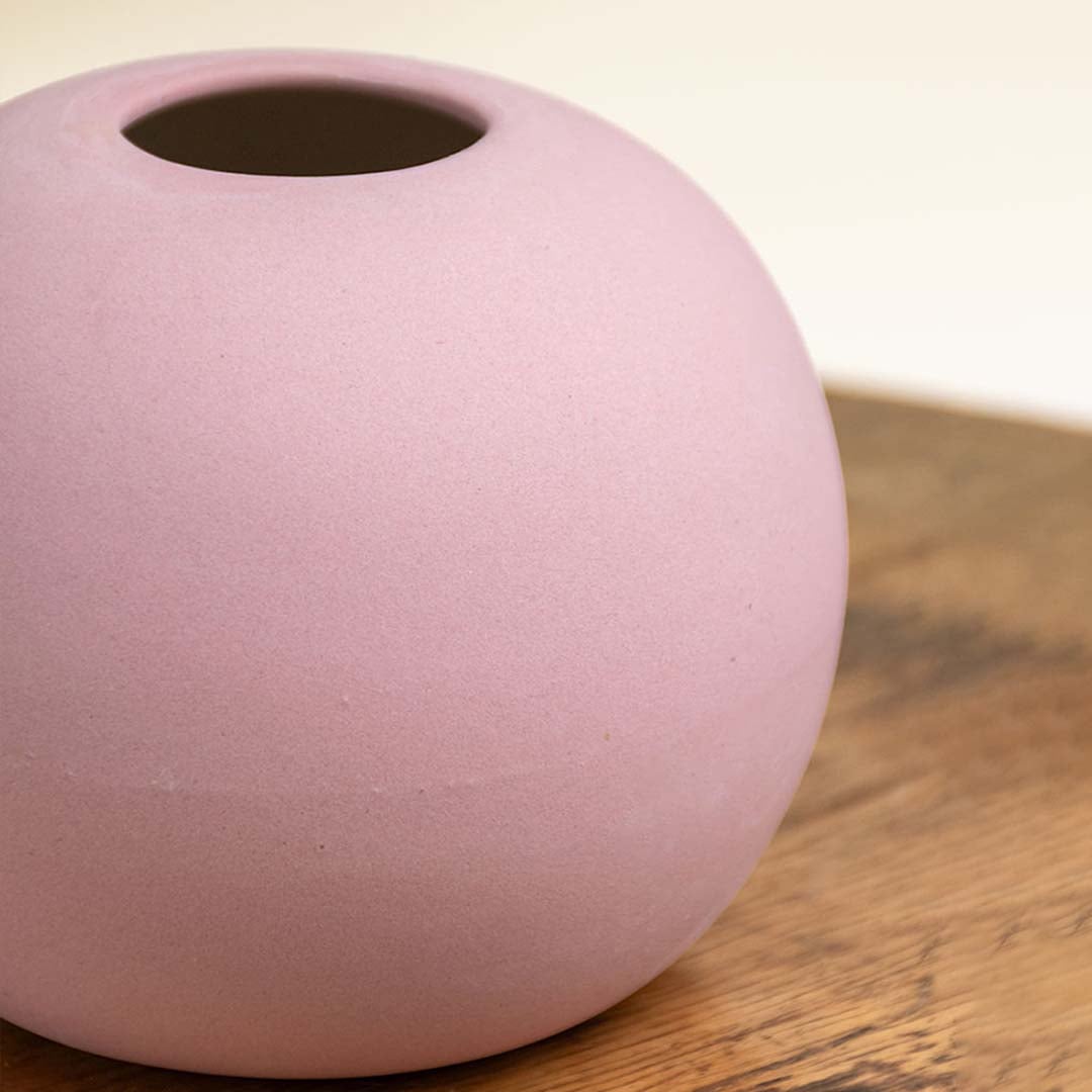 Detailed closeup of a matte pink ceramic round vase showing its smooth texture and refined finish ideal for stylish tabletop decor.