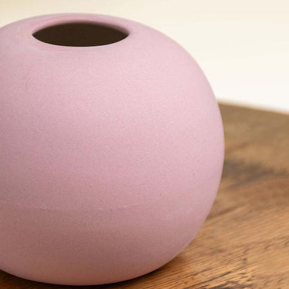 Detailed closeup of a matte pink ceramic round vase showing its smooth texture and refined finish ideal for stylish tabletop decor.